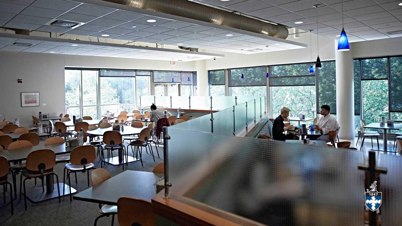 Spacious dining room with students eating in background.