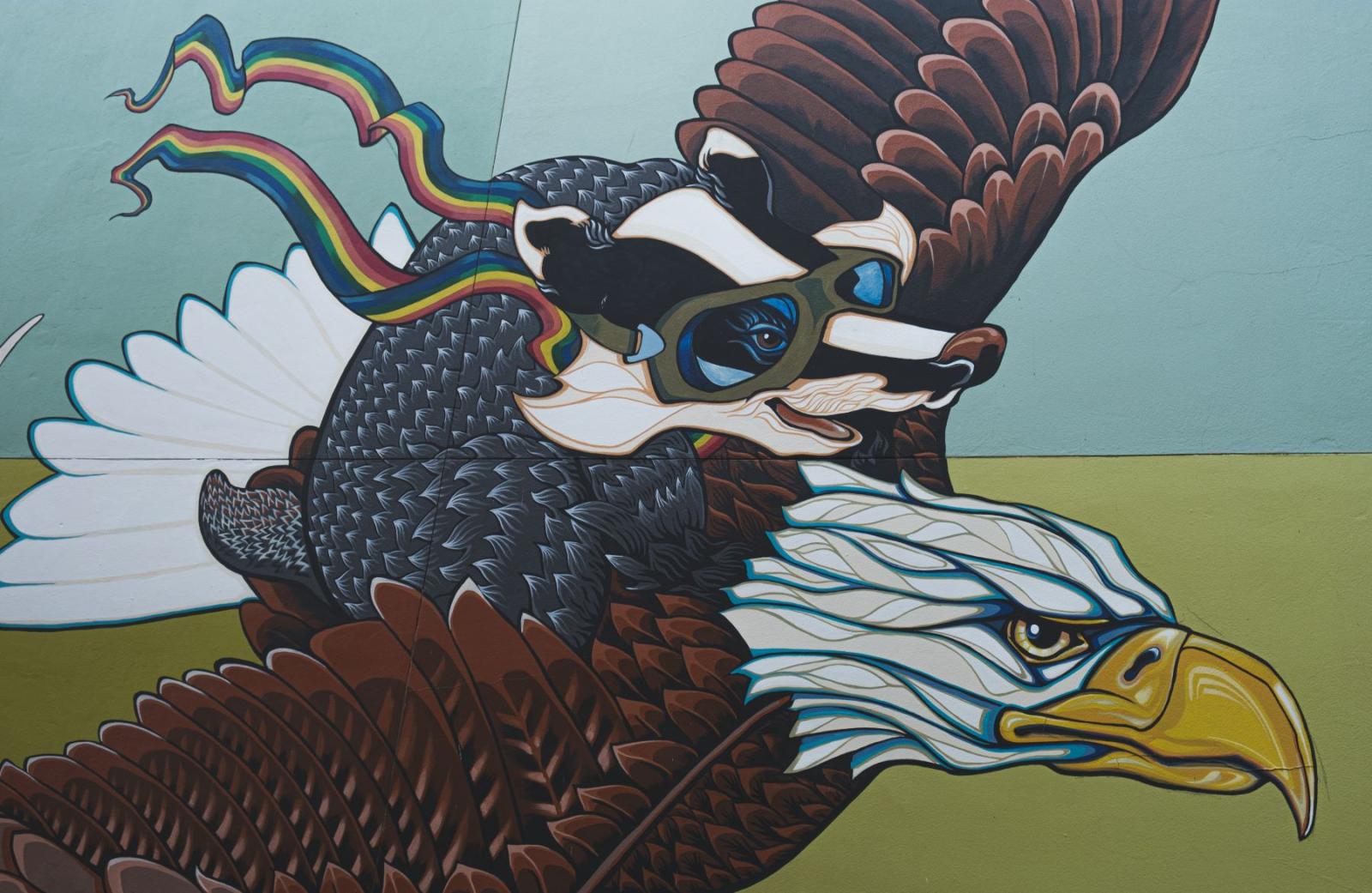 Mural of a skunk flying on the back of an eagle