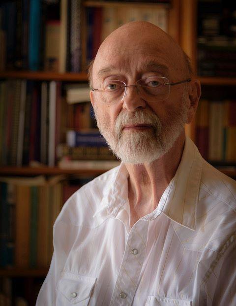 Photo of Jack Niles '54 infront of a bookshelf