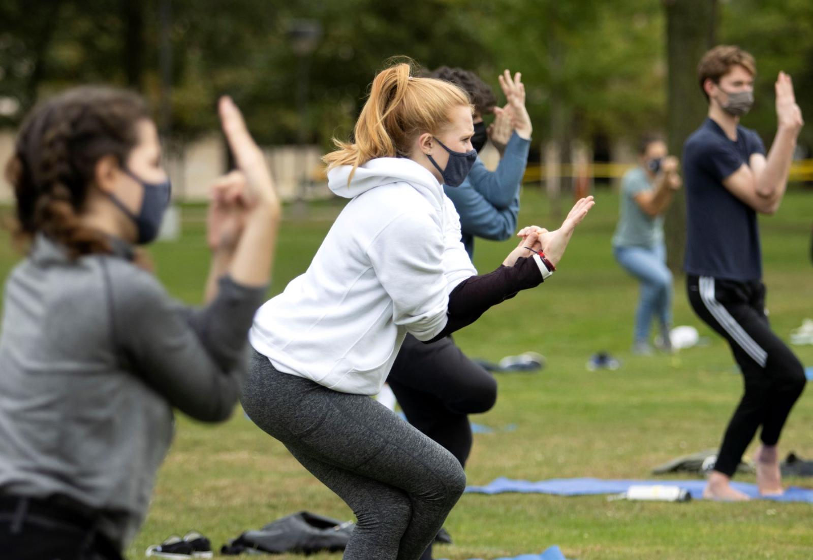 Students doing yoga on main hall green