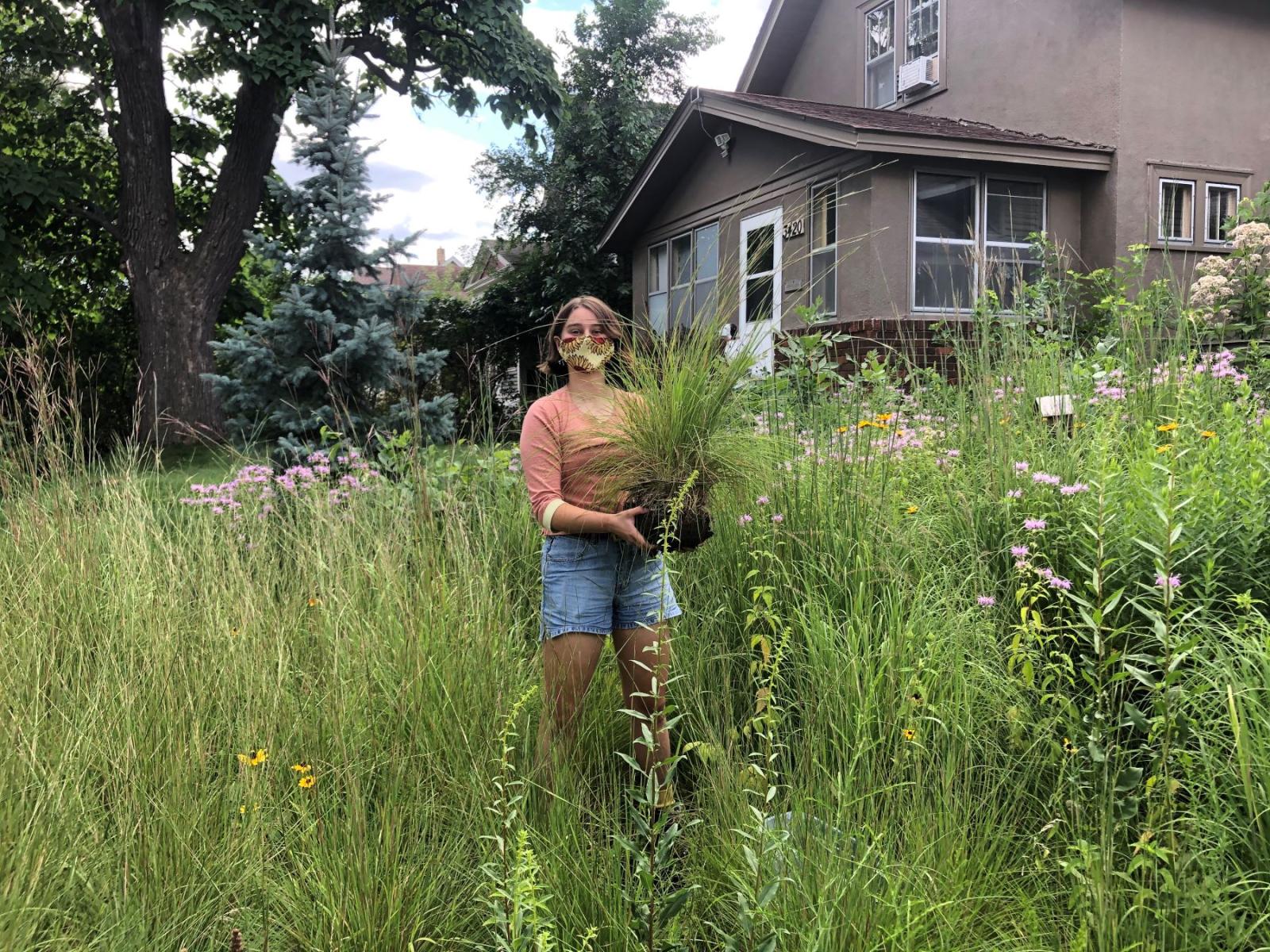 Bronwyn Earthman ’21 holding a plant in a field 