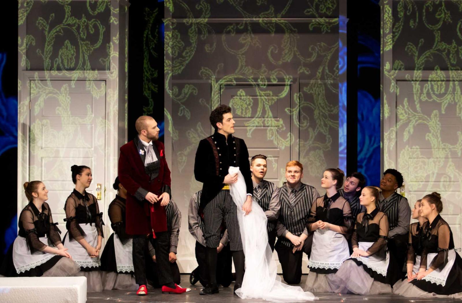 Erik Nordstrom as Count Almaviva and Max Muter as Figaro stand while chorus kneels down watching them, during a dress rehearsal for The Marriage of Figaro.