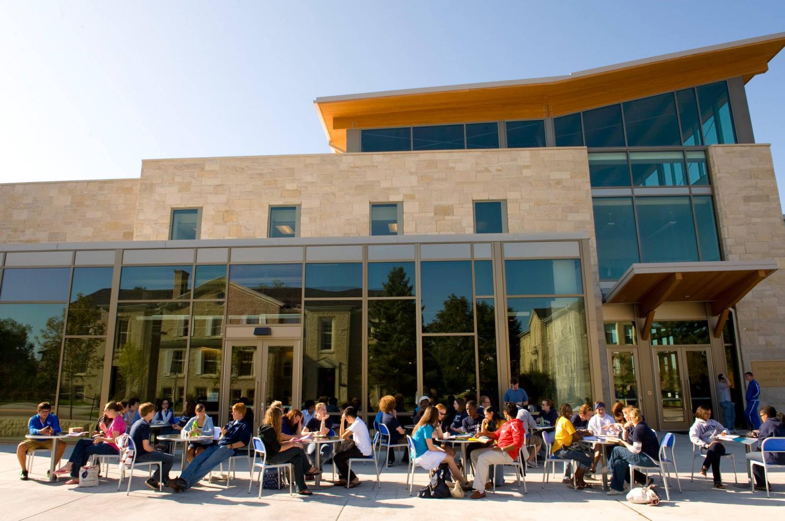 Exterior of Warch Campus Center with students sitting at tables