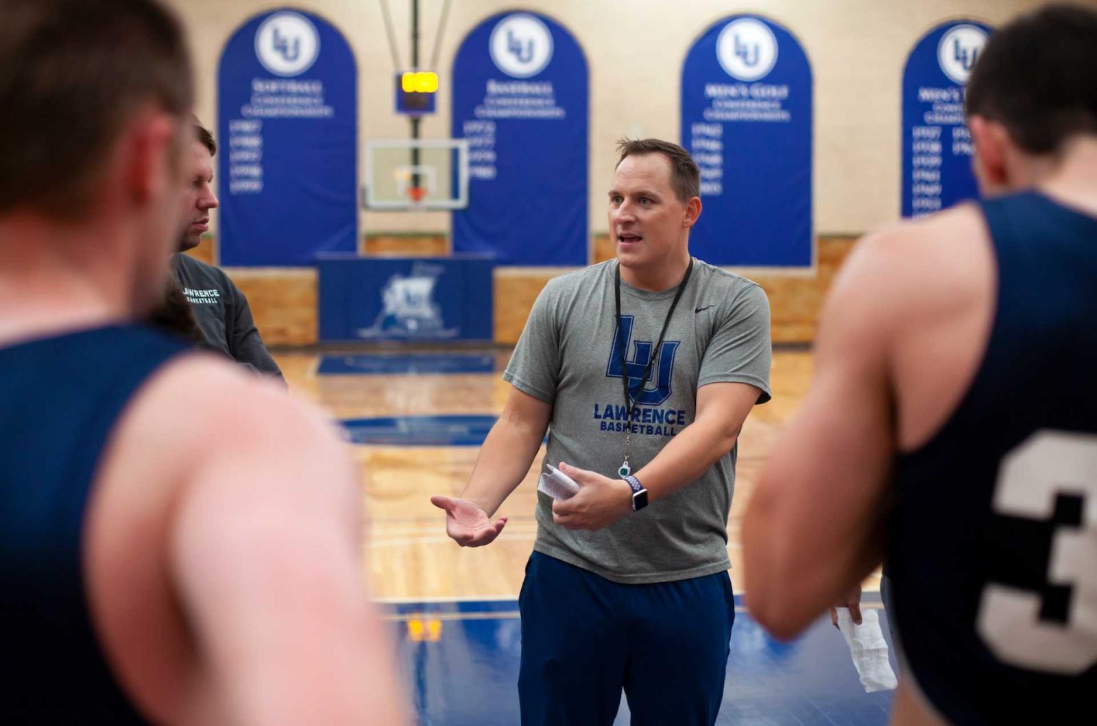 Casey Korn, the men's basketball team's new coach, talks to his players during practice.