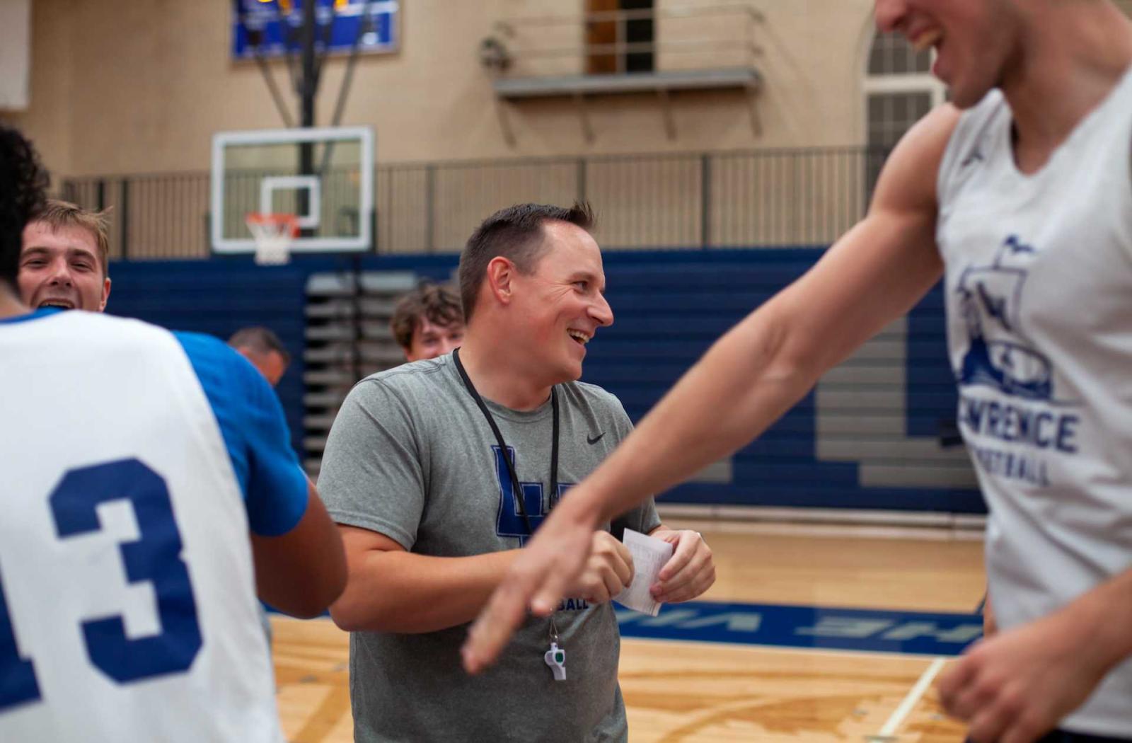 Casey Korn, the men's basketball team's new coach, talks happily to his players during practice.