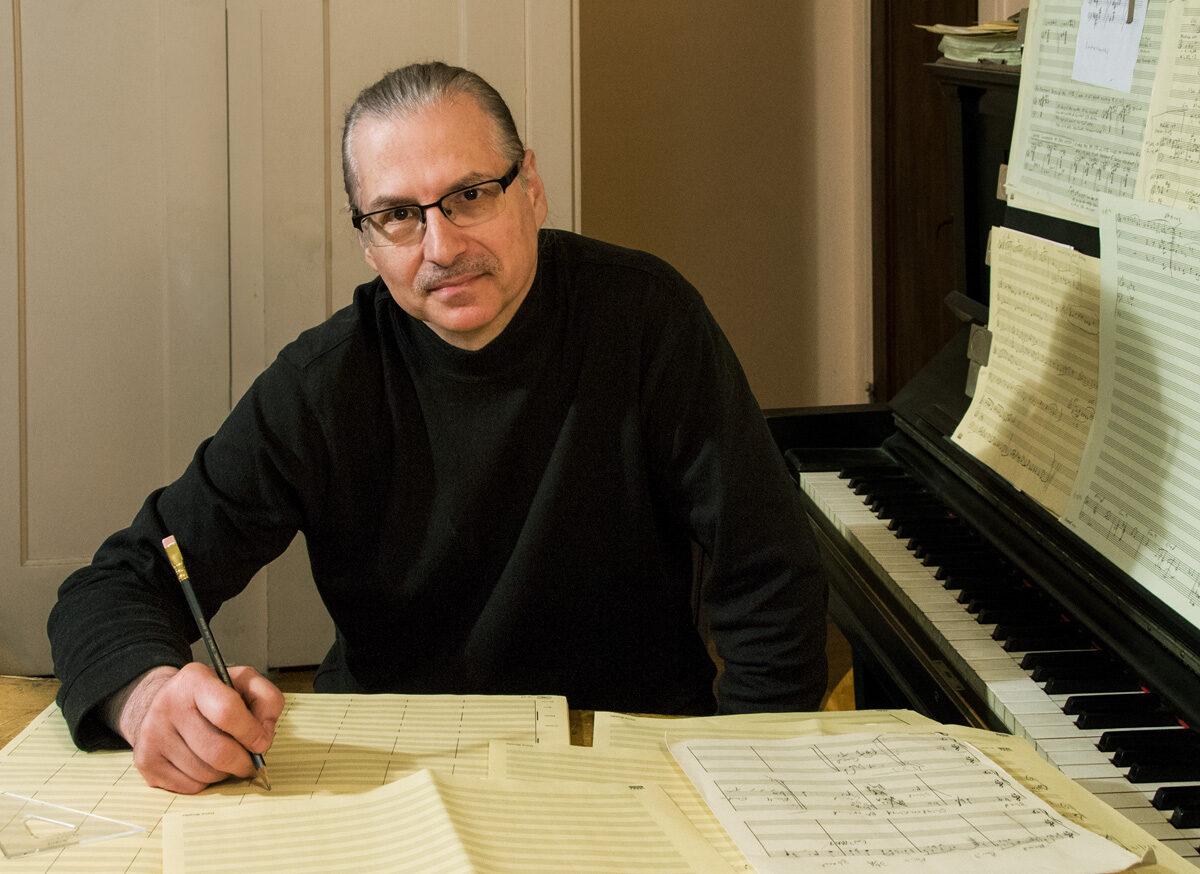 Dave Rivello at desk with sheet music and a pencil in hand.