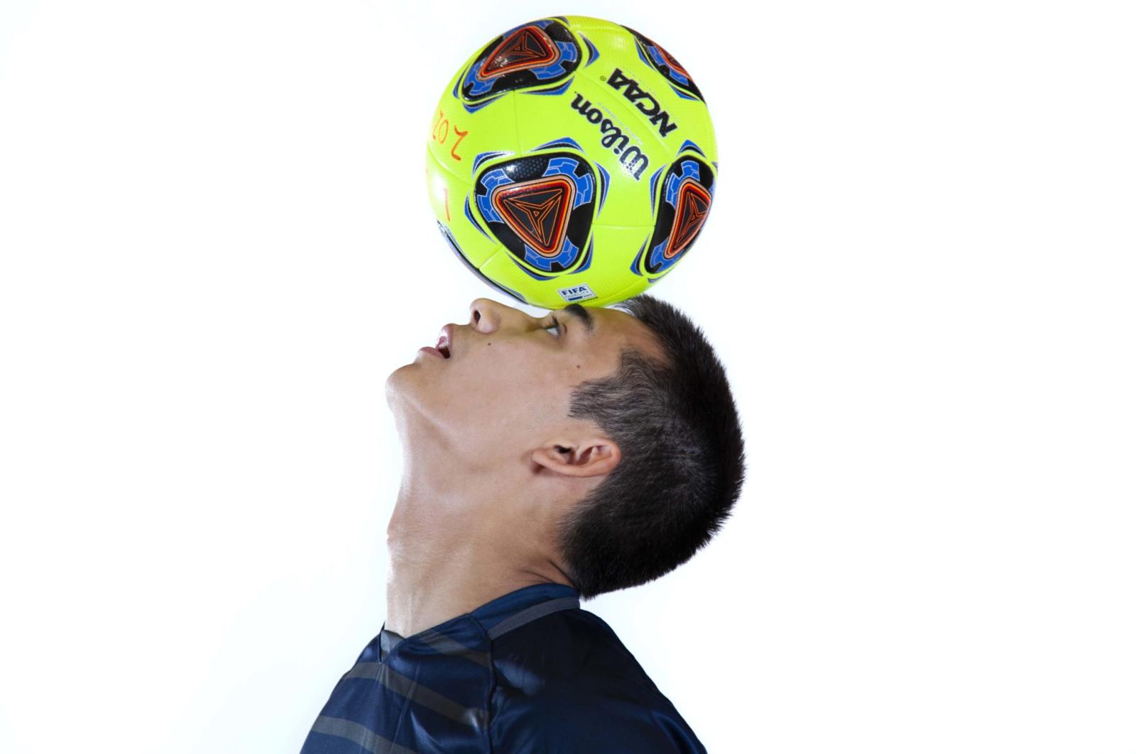 Soccer player Elliot Mueller balances a soccer ball on his forehead