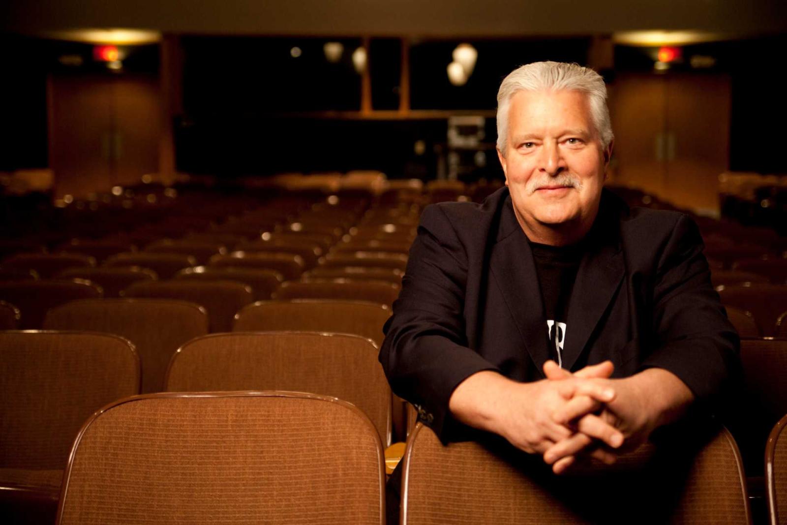 Fred Sturm sitting in an audience seat in an empty auditorium 