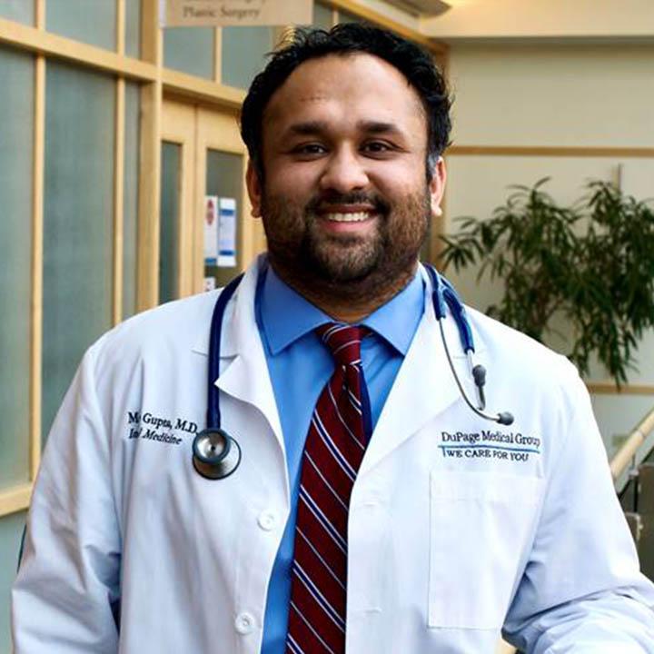 Dr. Mohit Gupta poses for a photo wearing his doctor jacket and stethoscope. 