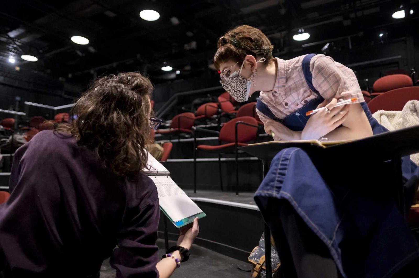 Nihan Baysal and Jana Casey, both sophomores, look at notes during a rehearsal in the Cloak Theater.