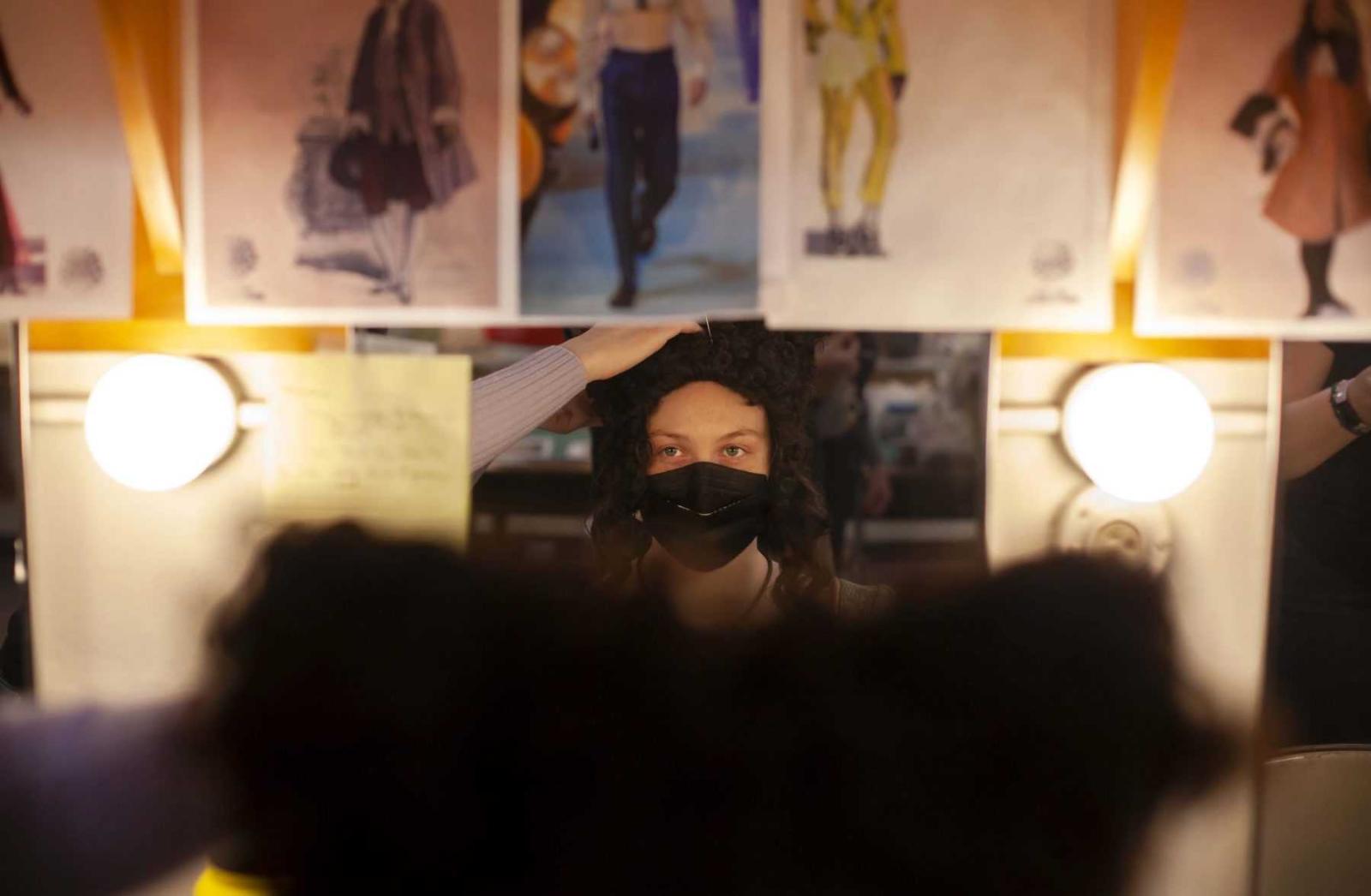 Lexi Praxl, a senior, sits in the costume shop as a wig is adjusted before rehearsal. 