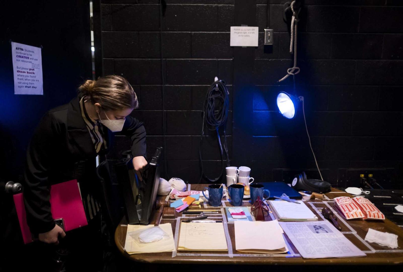 Nina Broberg, a sophomore, checks props before rehearsal backstage in the Cloak Theater.