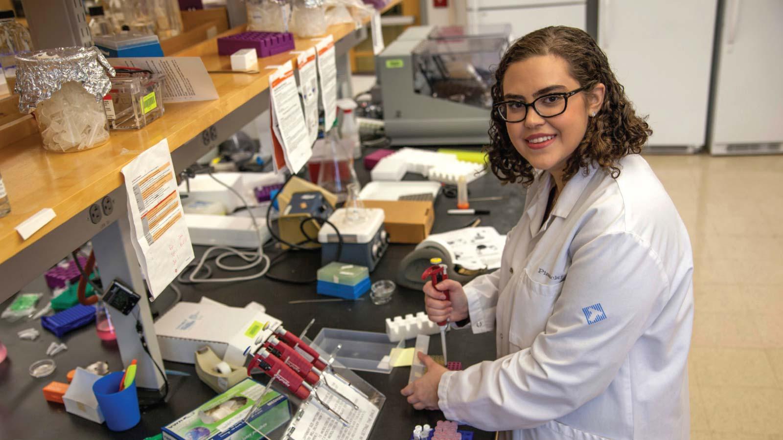 Madeline Schubert in a lab wearing a lab coat