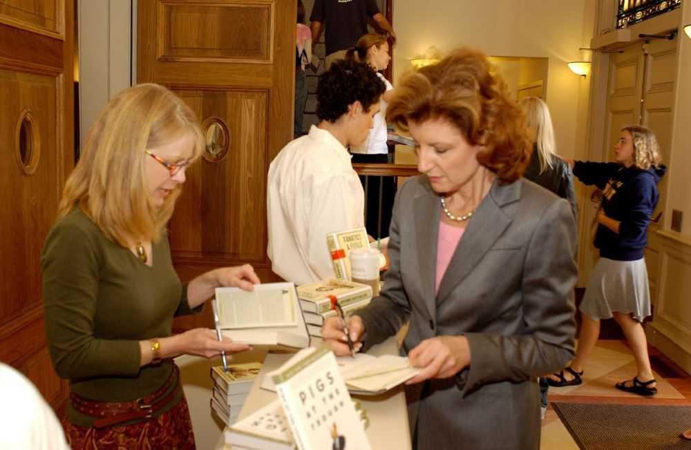Arianna Huffington signs a book in the lobby of Memorial Chapel as a woman looks on.