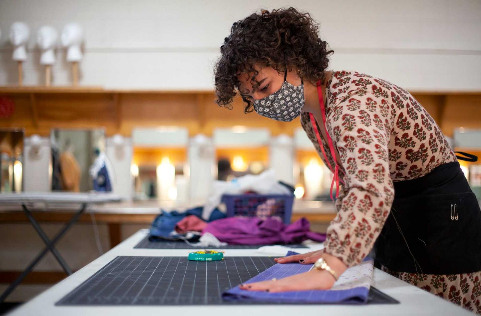 Maggie McGlenn works with cloth materials in Lawrence's theater costume shop.