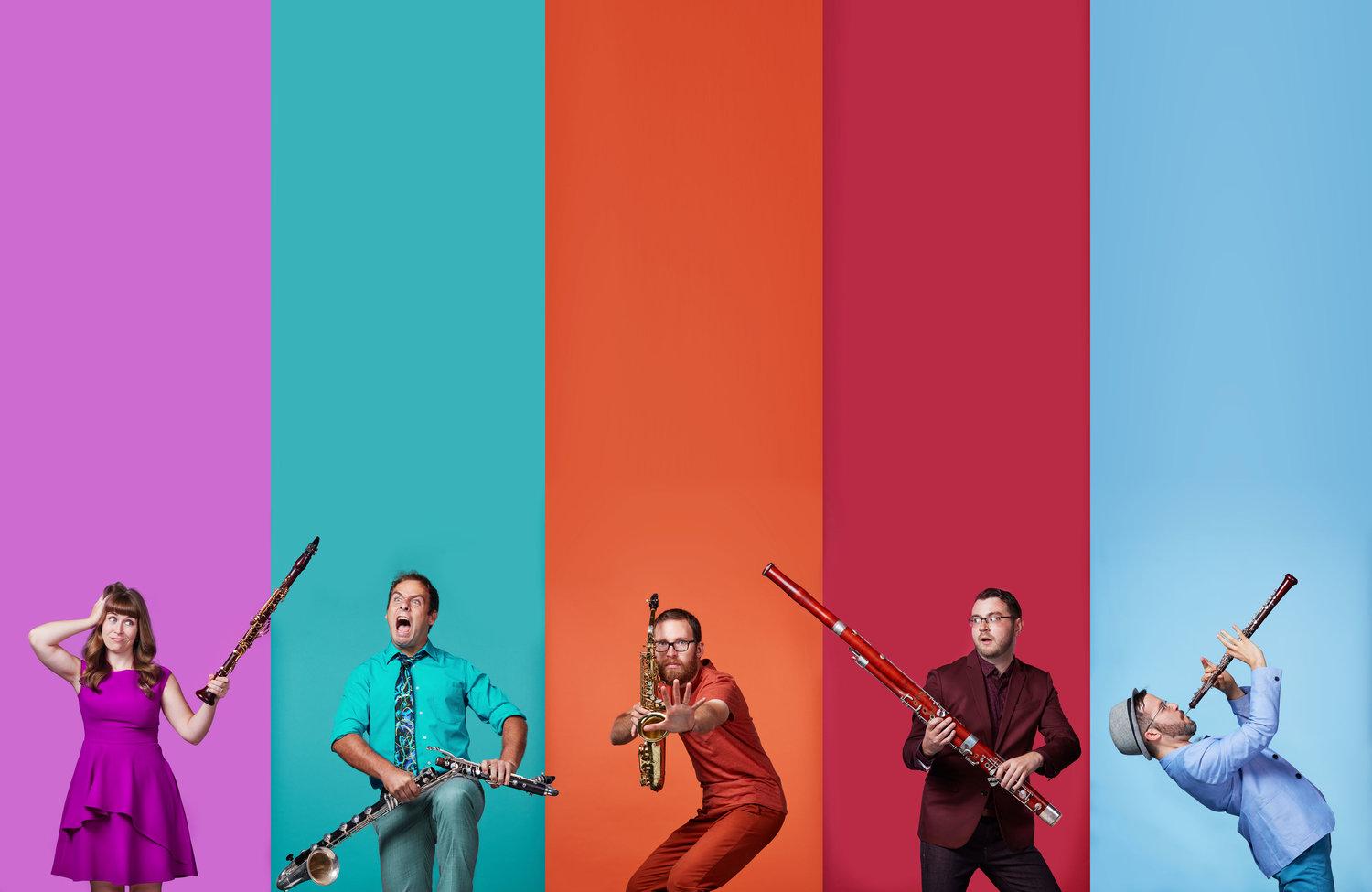 Perfrormers of Akropolis Quintet pose with their instruments in front of a background of color blocks