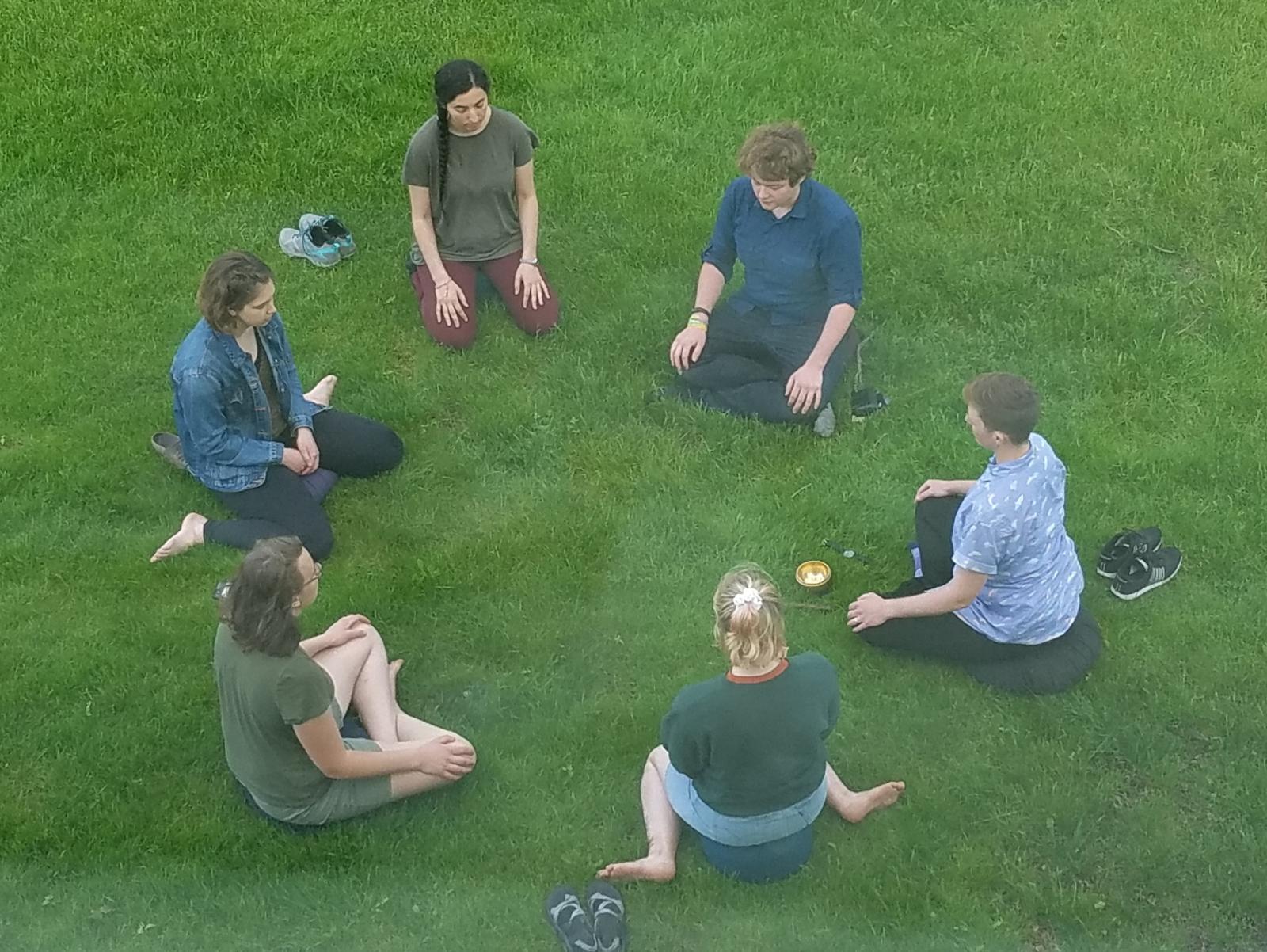 People meditating outside in a circle