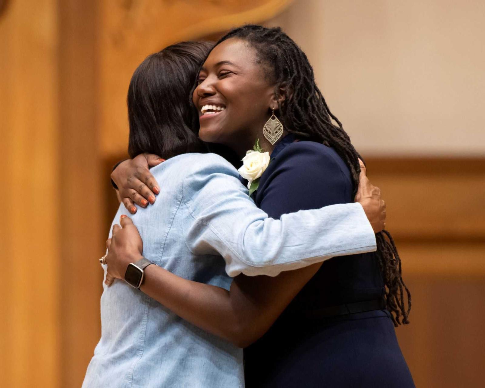 Paris Brown Wicker '07 gets a hug from President Laurie Carter during the presentation of the Alumni Awards.