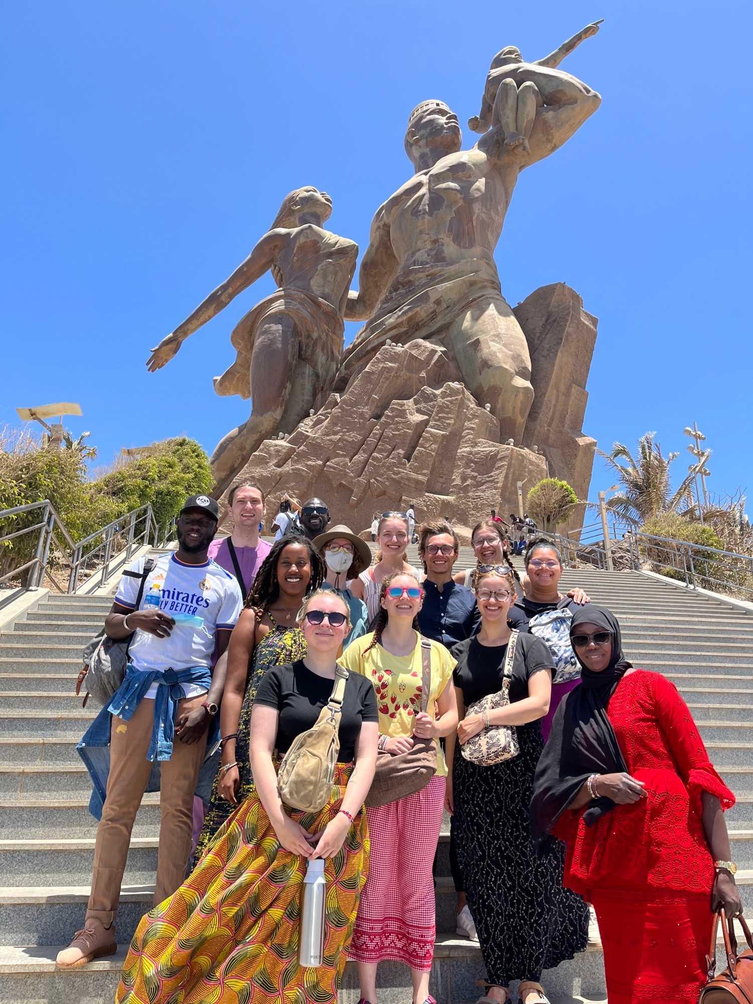 Lawrence students pose in front of a statue in Senegal.