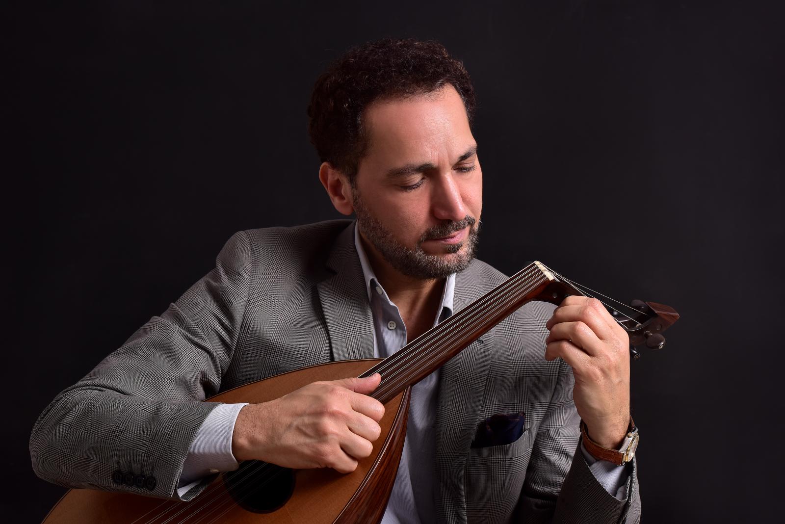 Man playing a Middle Eastern stringed instrument.