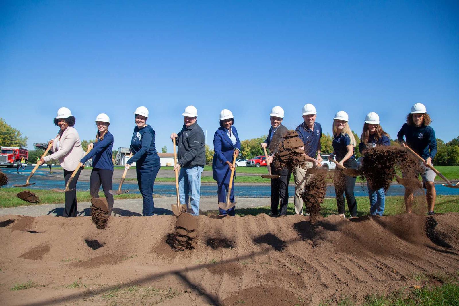 President Laurie Carter, the the center, joins other university and building officials with the first shovels of dirt at the Whiting Field Track.