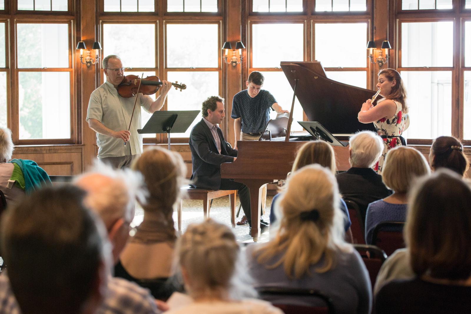 Muscians perform for a seated audince.