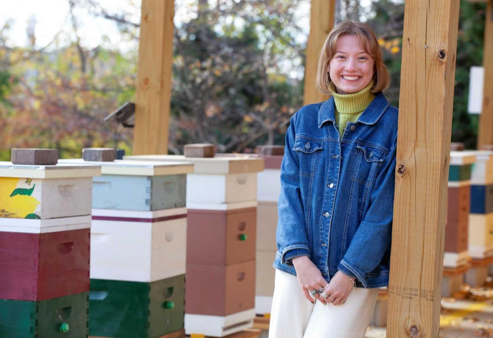 Bella Goland poses for a photo in the apiary in SLUG.
