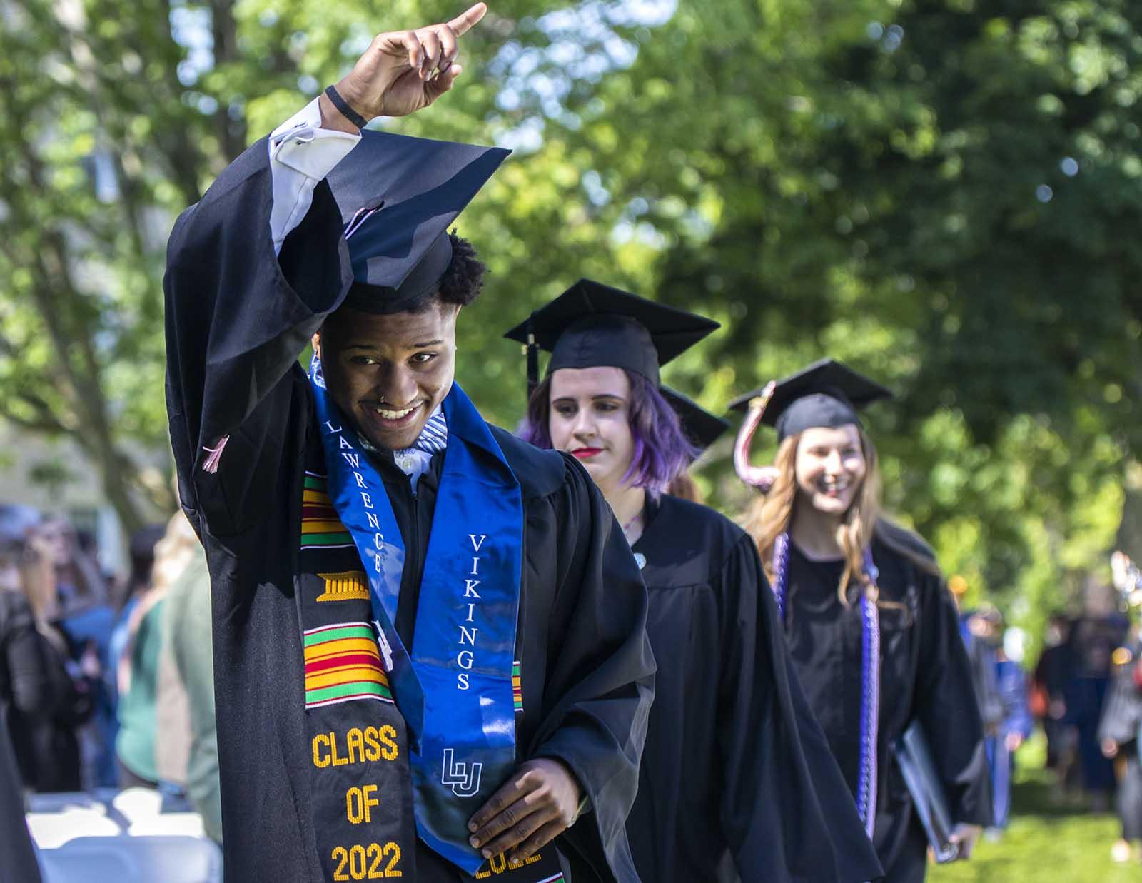 Cameron Wicks points to those in attendance at Commencement on Main Hall Green.