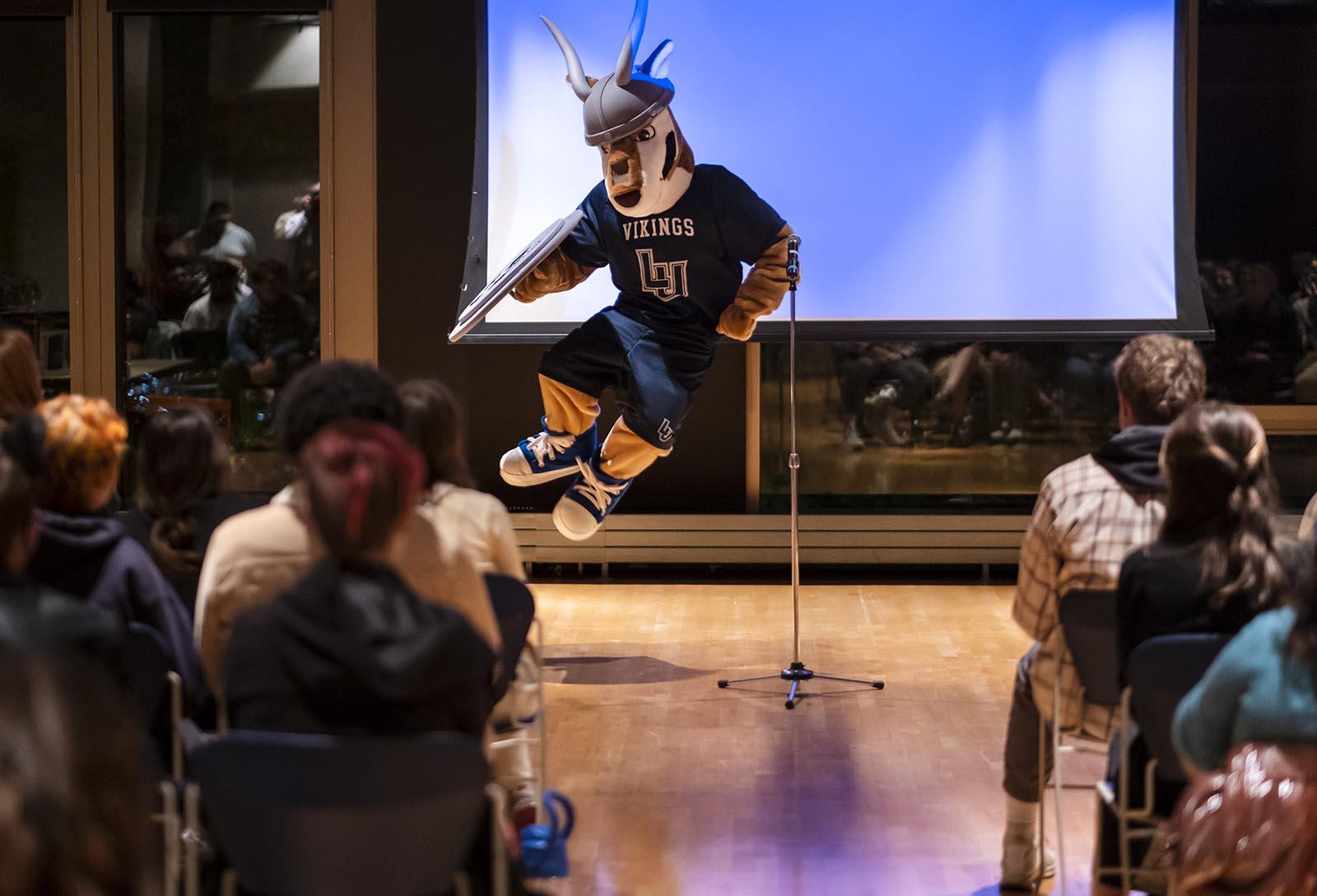The mascot Blu does a heel kick during a talent show.