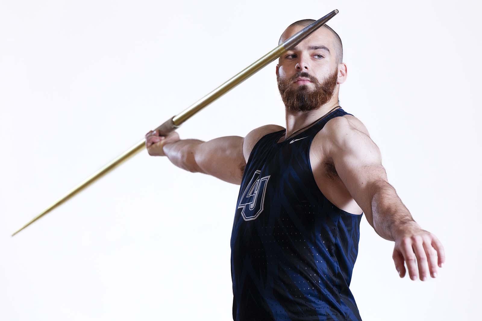 Sean McLaughlin holds a javelin as he stands for a portrait during Media Day. 