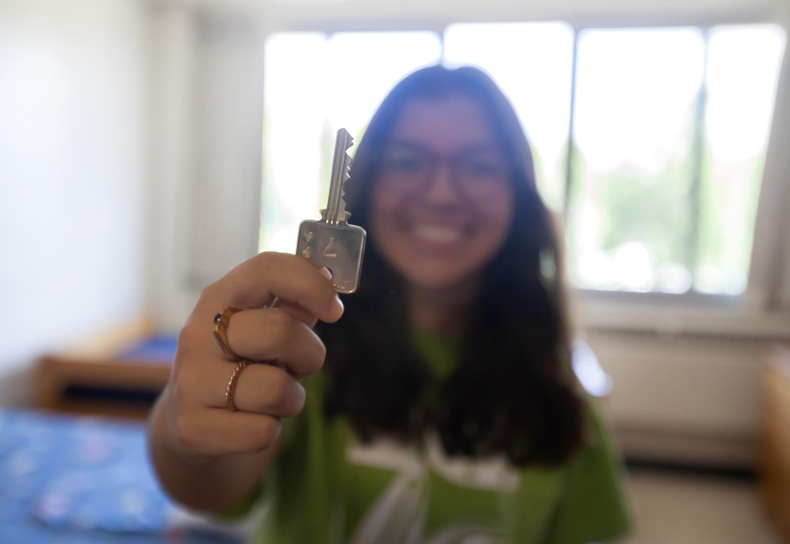 student showing her room key