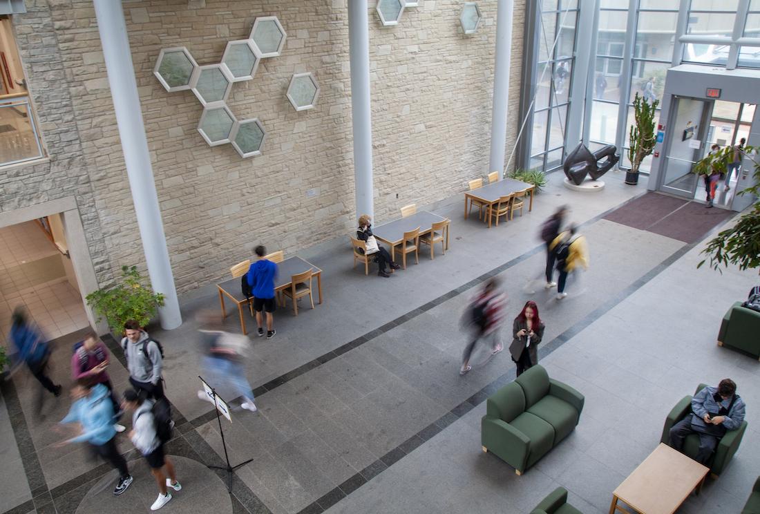 Students move about inside the Science Atrium.