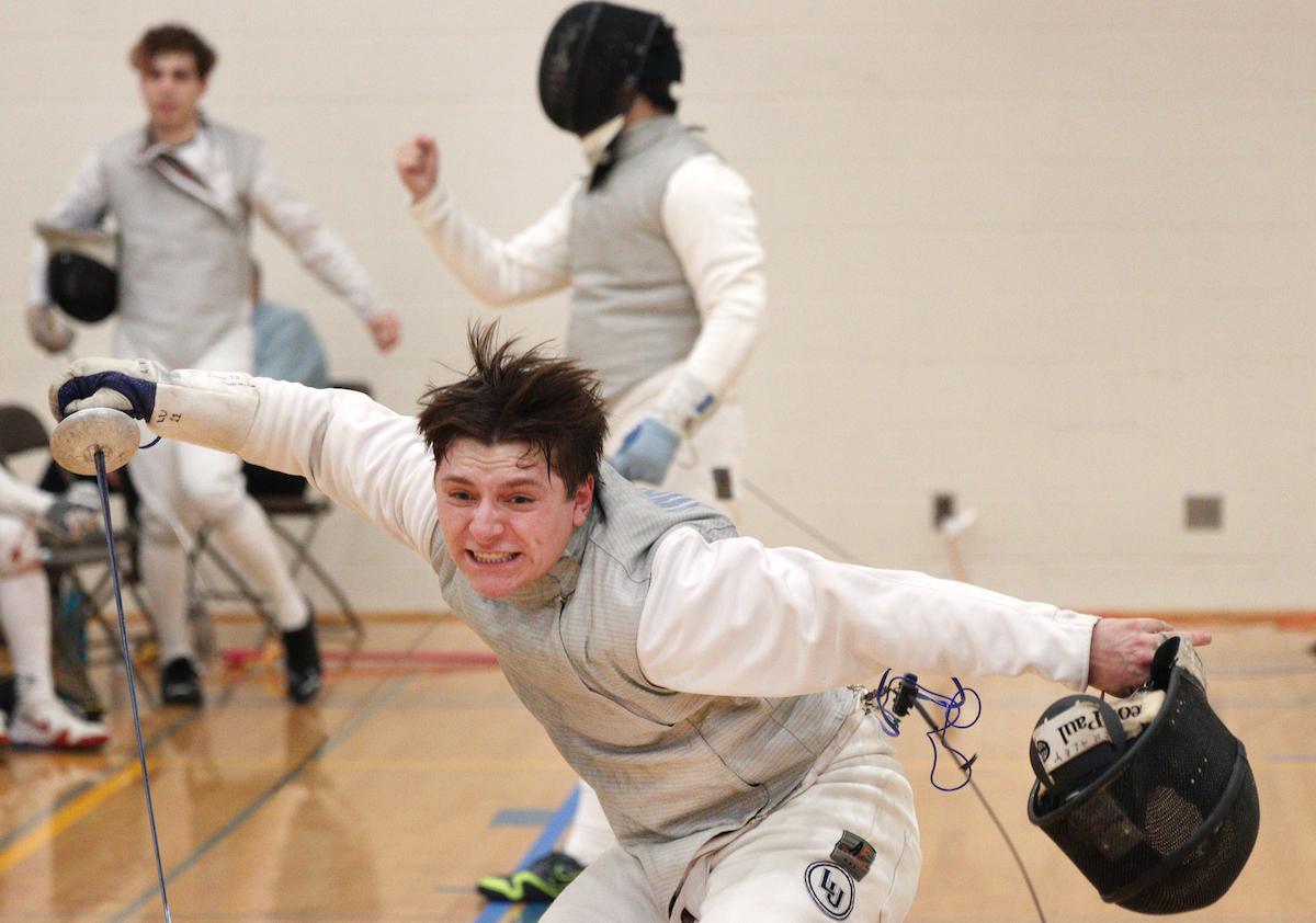 Thomas Craley, a sophomore in men's foil, removes his helmet and celebrates during a Lawrence tournament.