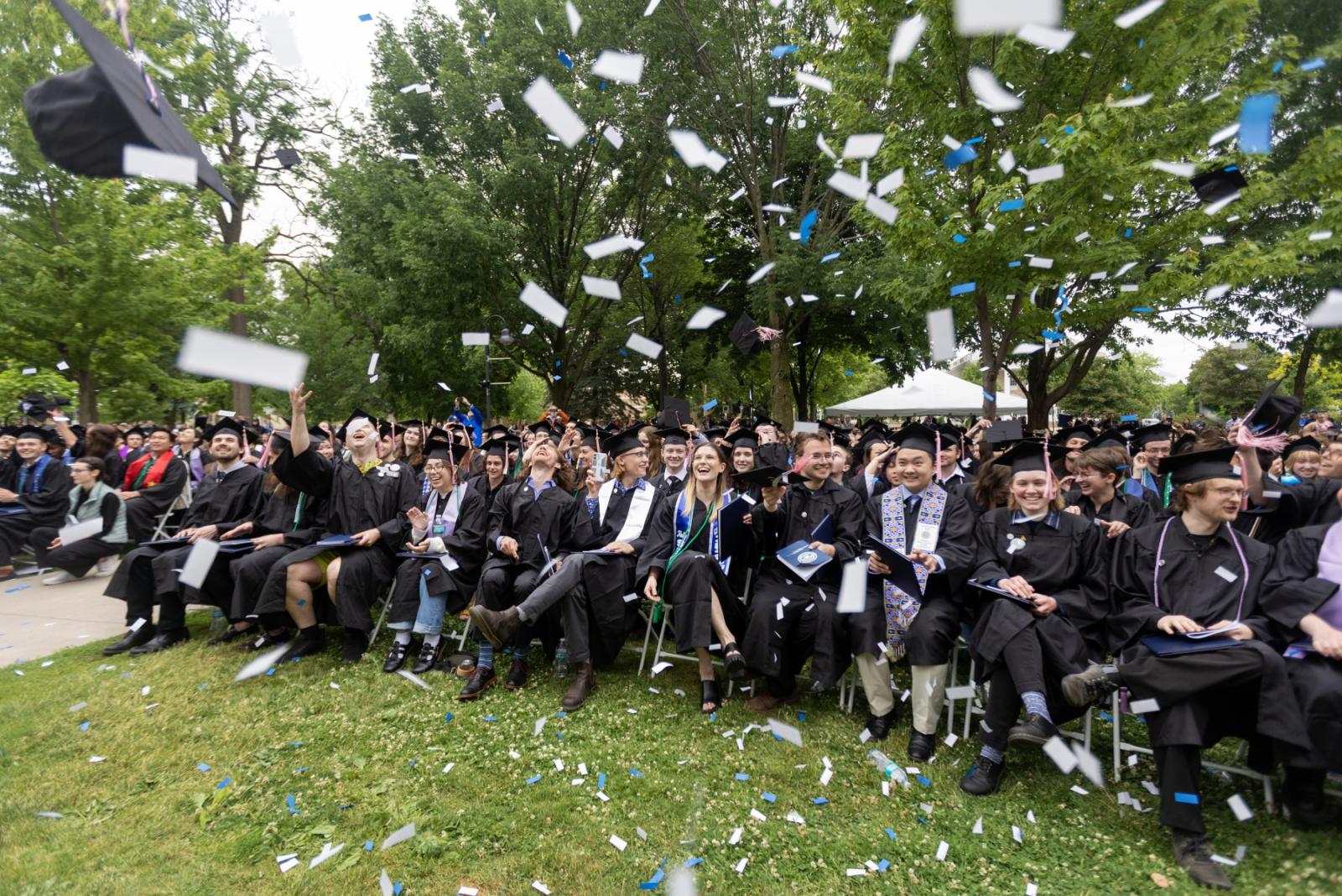 Confetti and hats fly among the graduates at close of Commencement.
