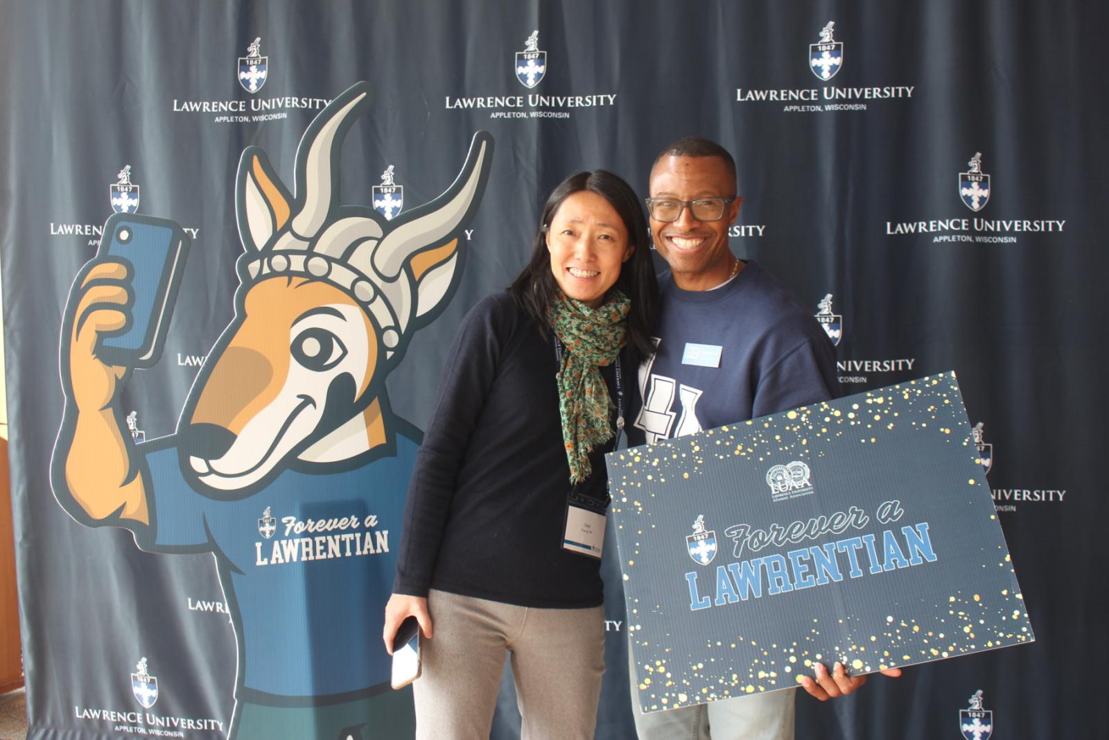 Jiayi Ling Young '94 and Tracy Donald '95 pose with Forever a Lawrentian signs.