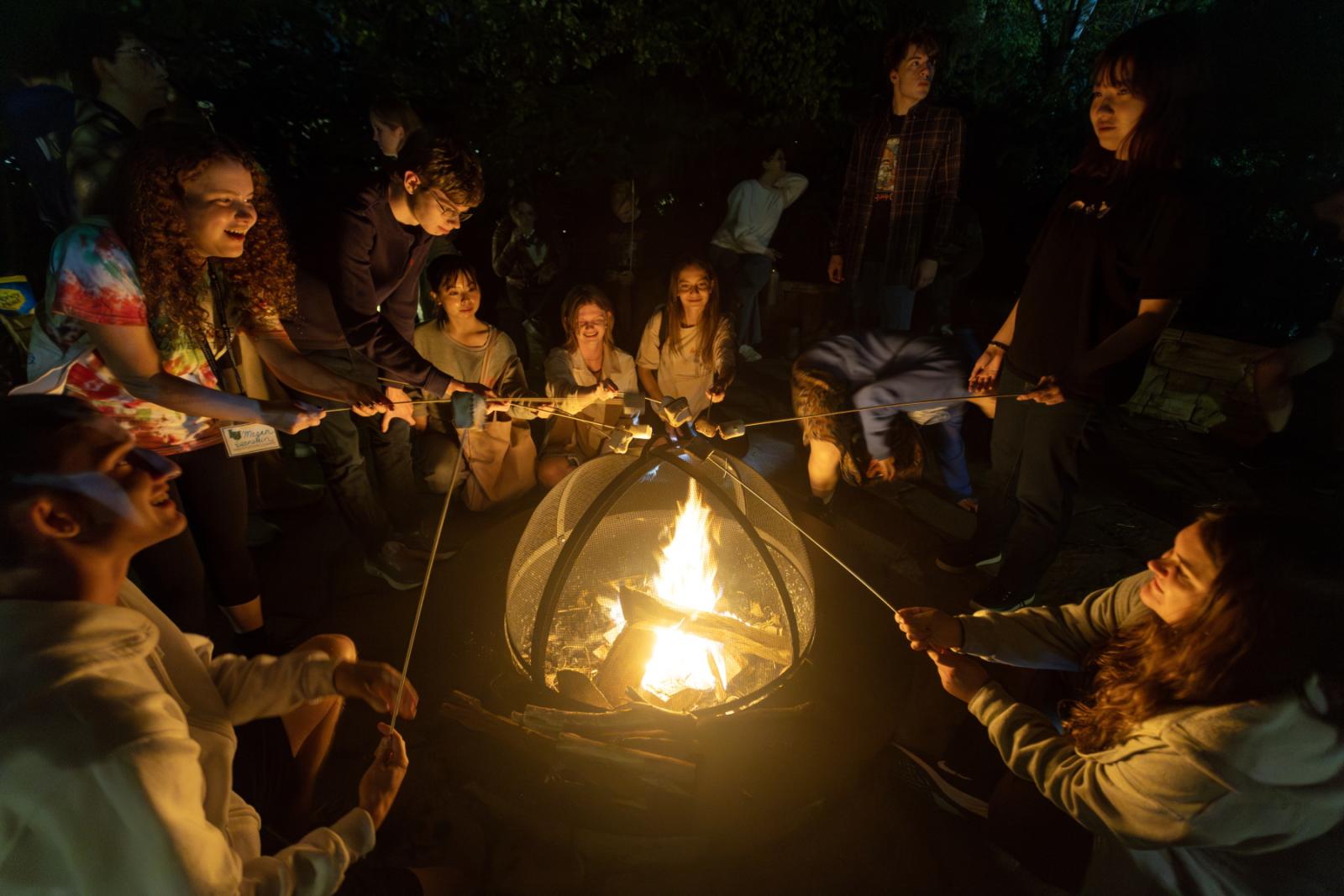 Students make s'mores at a bonfire in SLUG.