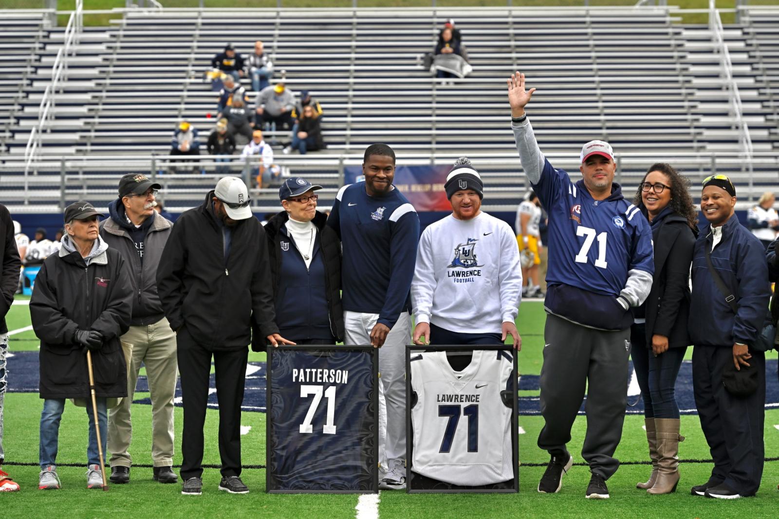 Coach Tony Aker joins members of Joe Patterson's family on the field to celebrate the No. 71 being retired.