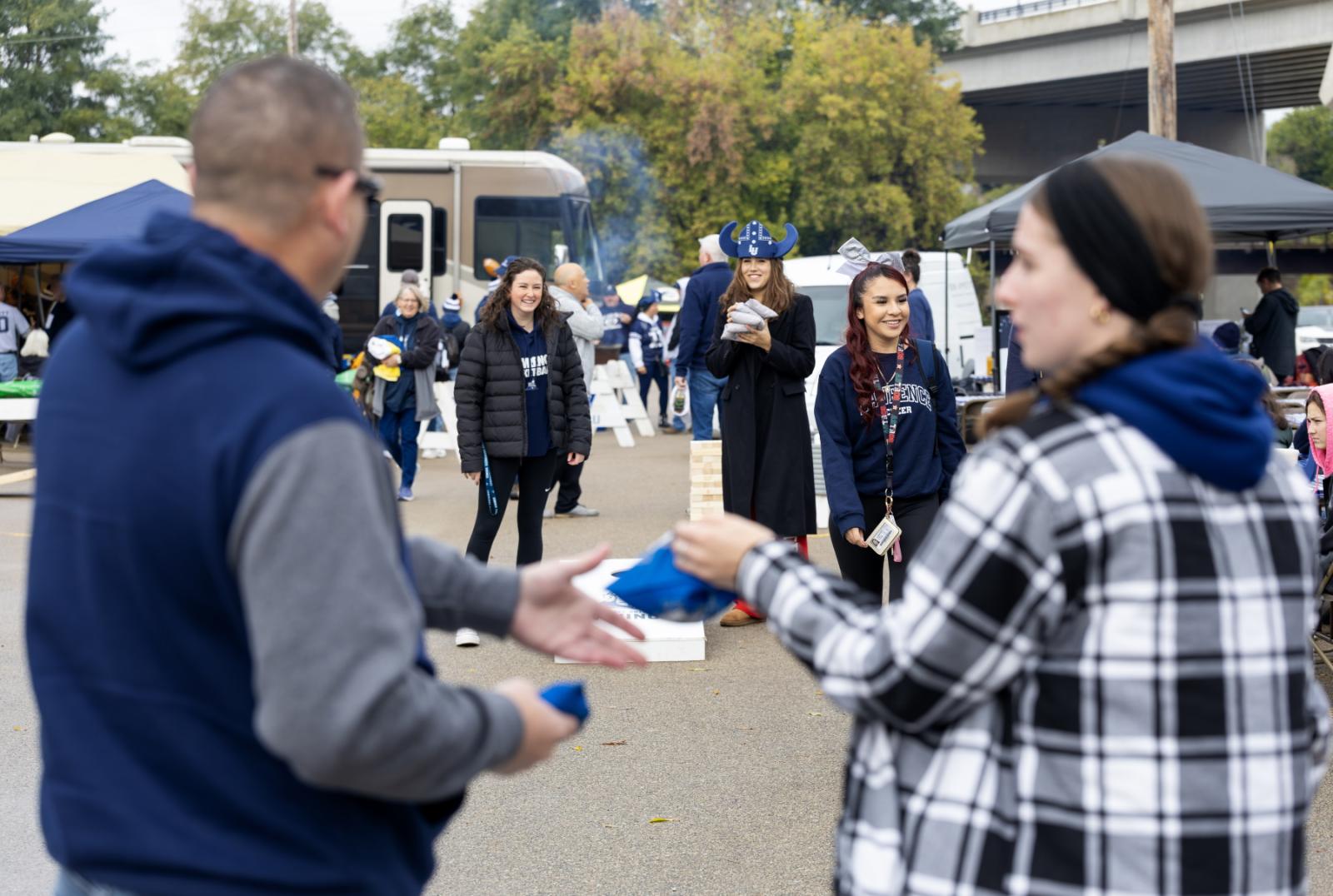 A game of cornhole is played during the tailgate party.