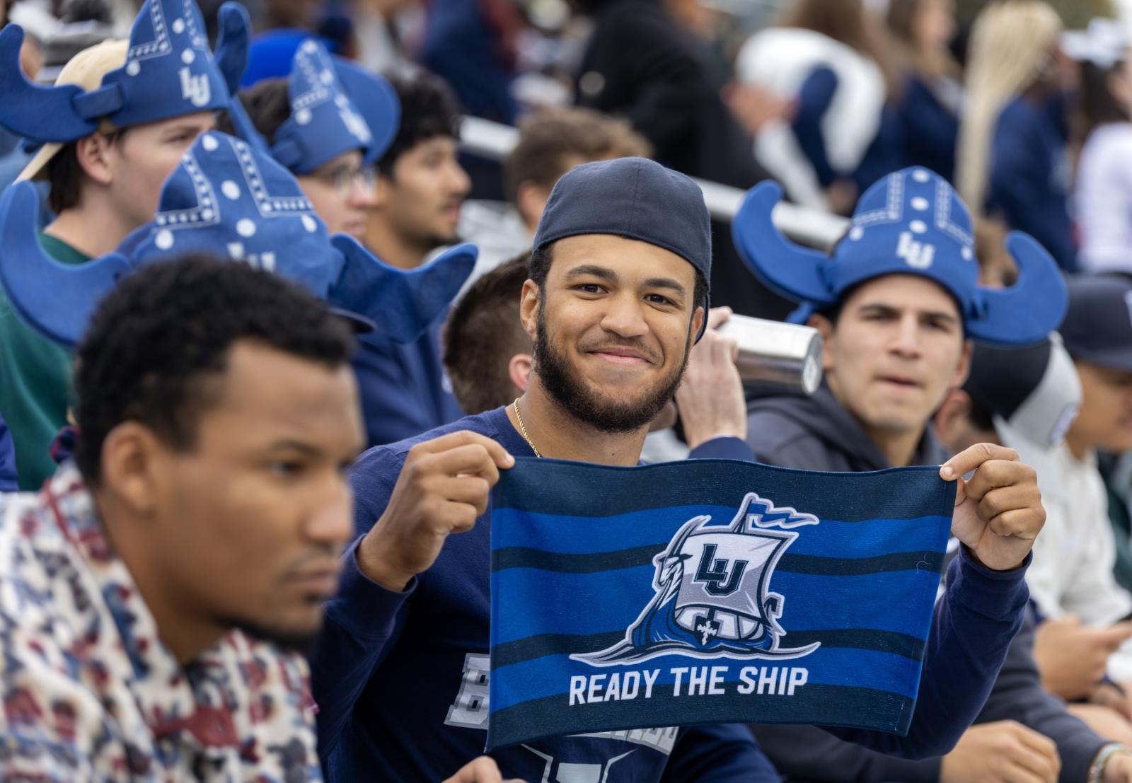 A student holds a Ready the Ship towel at Banta Bowl.