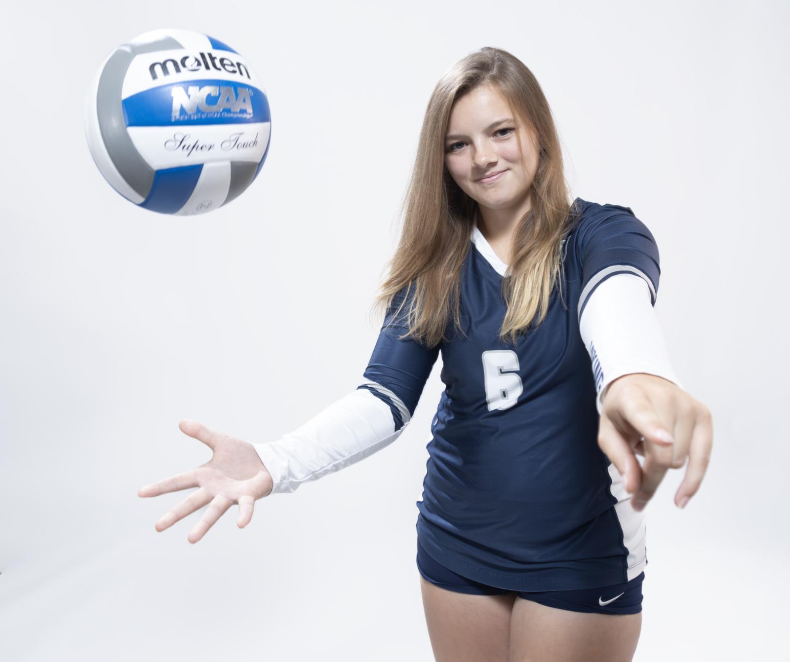 Taylor Hughes plays with a volleyball during a Media Day photo shoot.