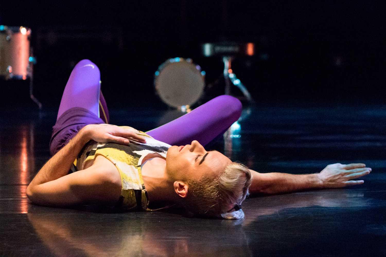 Dancer laying on ground with arm outstretched