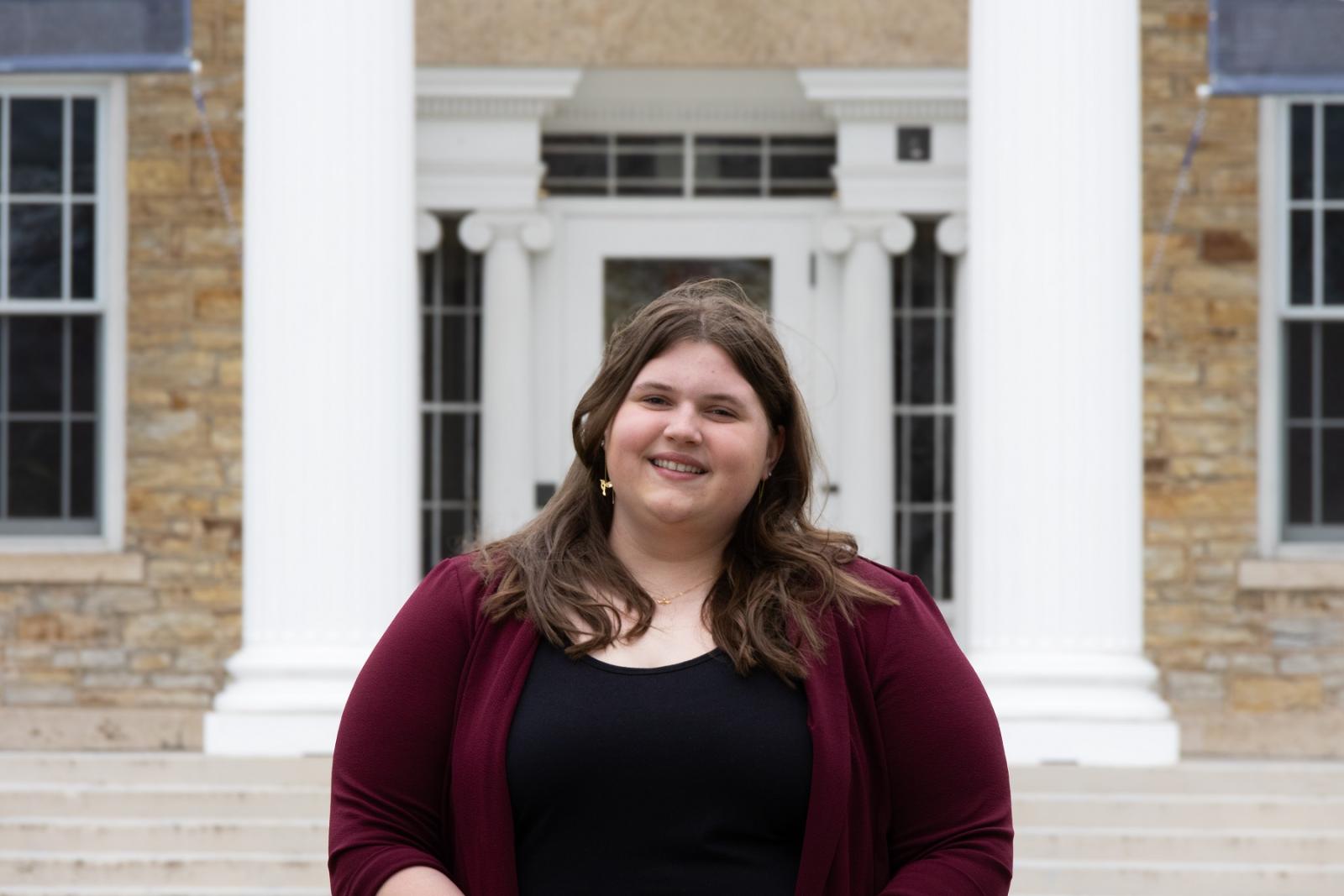 Brooklyn Schara poses for a photo in front of Main Hall.