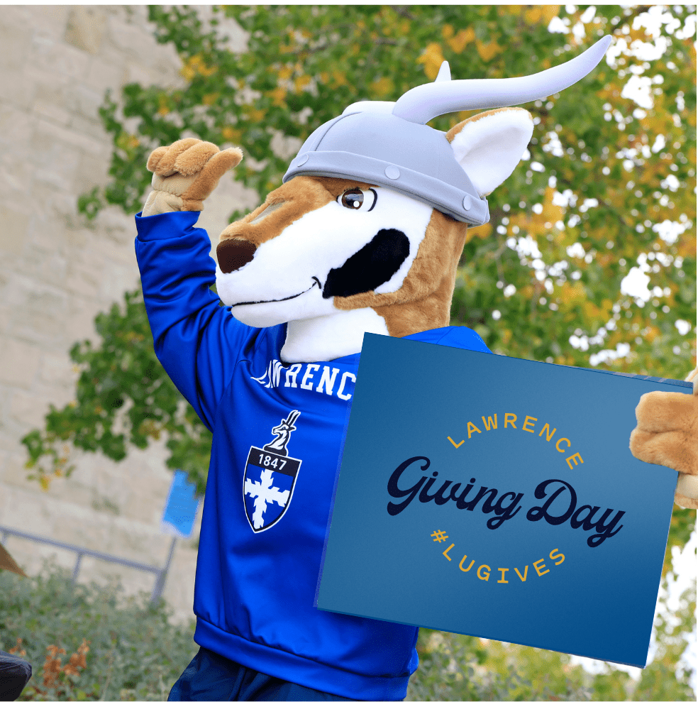 Blu cheers on the crowd while holding a Giving Day sign