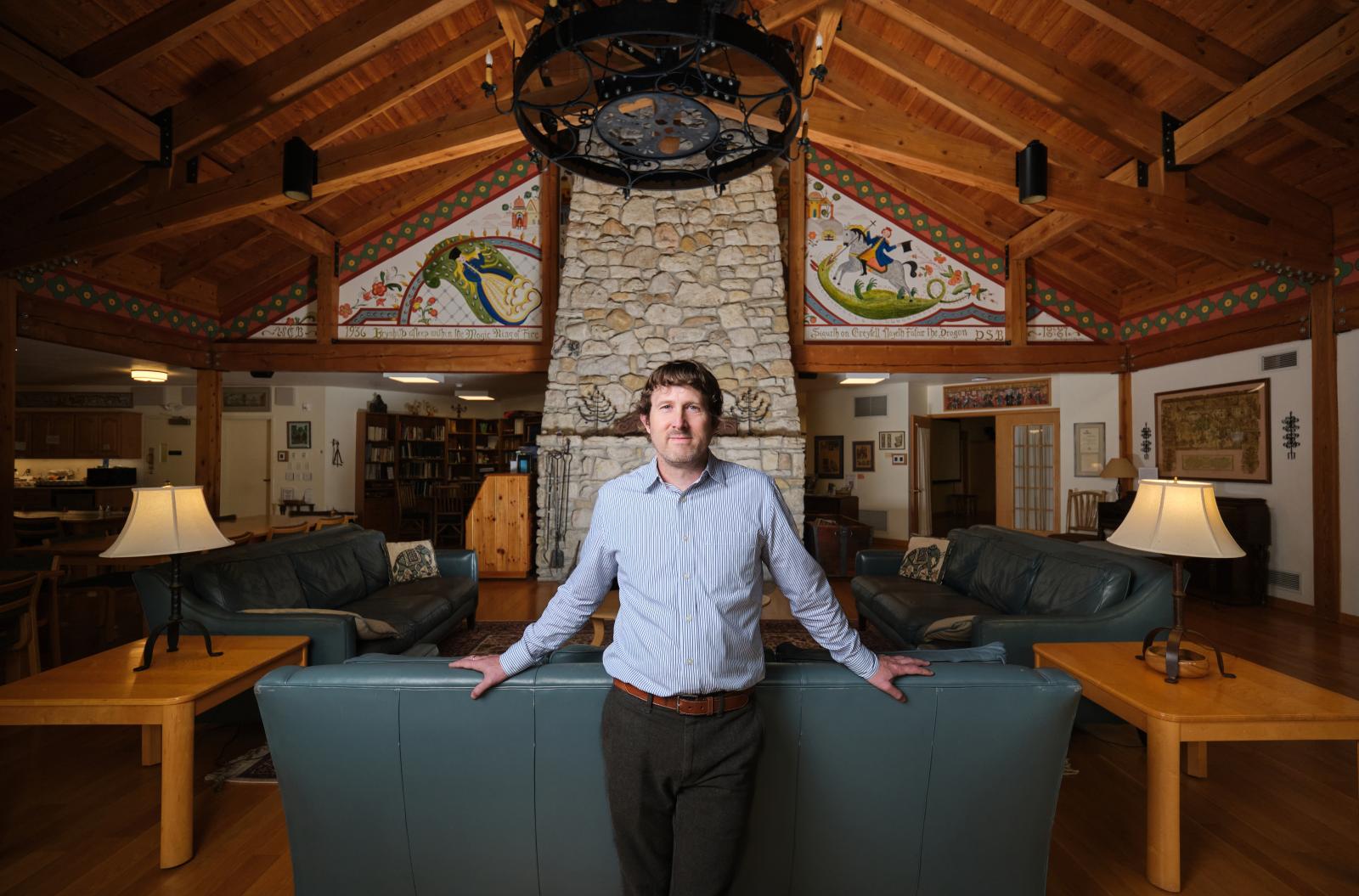 Tom McKenzie stands in the Bjorklunden lodge living room