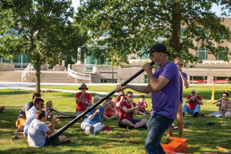 Brian Pertl ’86 plays a didjeridu for community members as part of the Mile of Music Education Team.