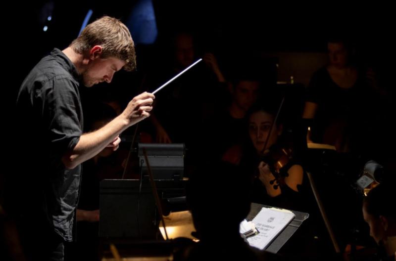 Andrew Crooks directs music during a dress rehearsal