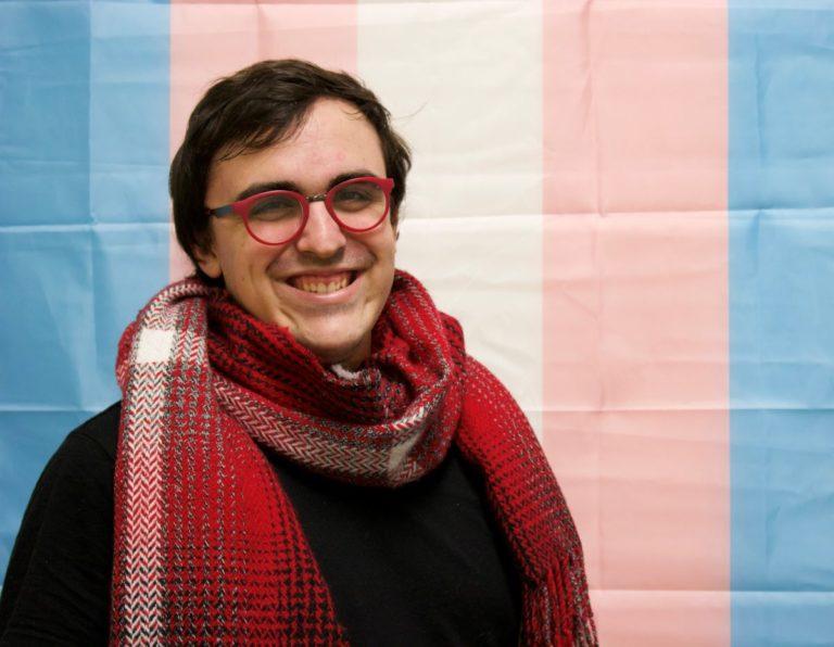 Sterling Ambrosius, wearing a red scarf, smiles at the camera.