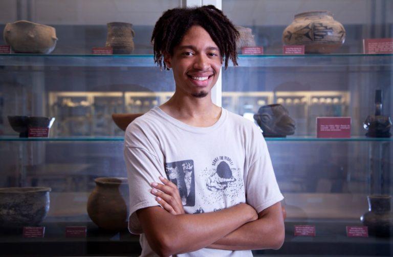 Terrence Freeman stands in front of a pottery display and smiles at the camera.