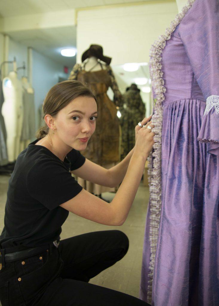 Mads Layton adjusts the stitching on an old-fashioned purple gown.