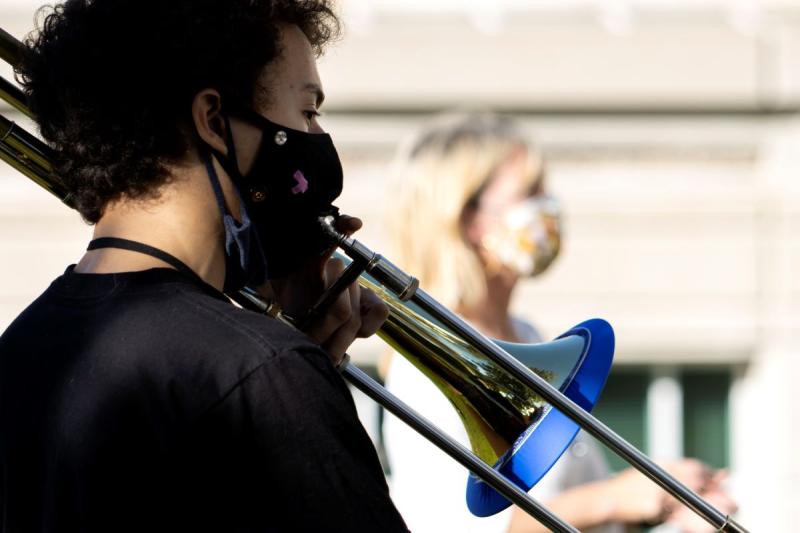 Matvei Mozhaev playing the trombone outside 